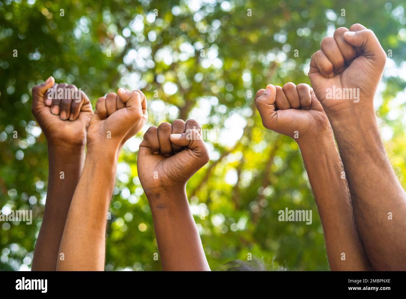 Concetto di unità nella diversità o uguaglianza che mostra da Gruppo di mani di pugno che si alzano durante il mese di marzo Foto Stock
