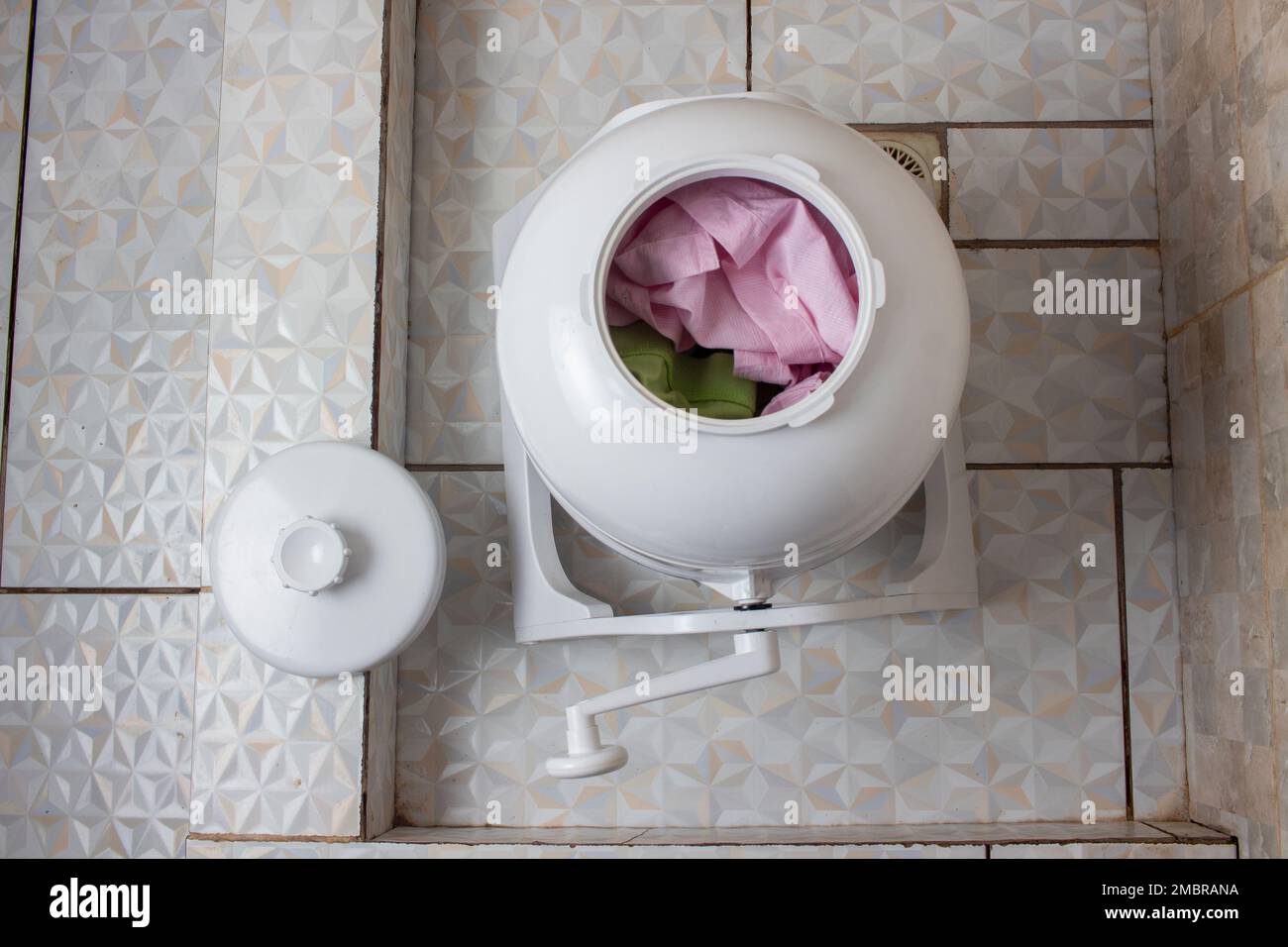 I vestiti sono caricati in una lavatrice manuale portatile, non elettrica, ecocompatibile e conveniente Foto Stock