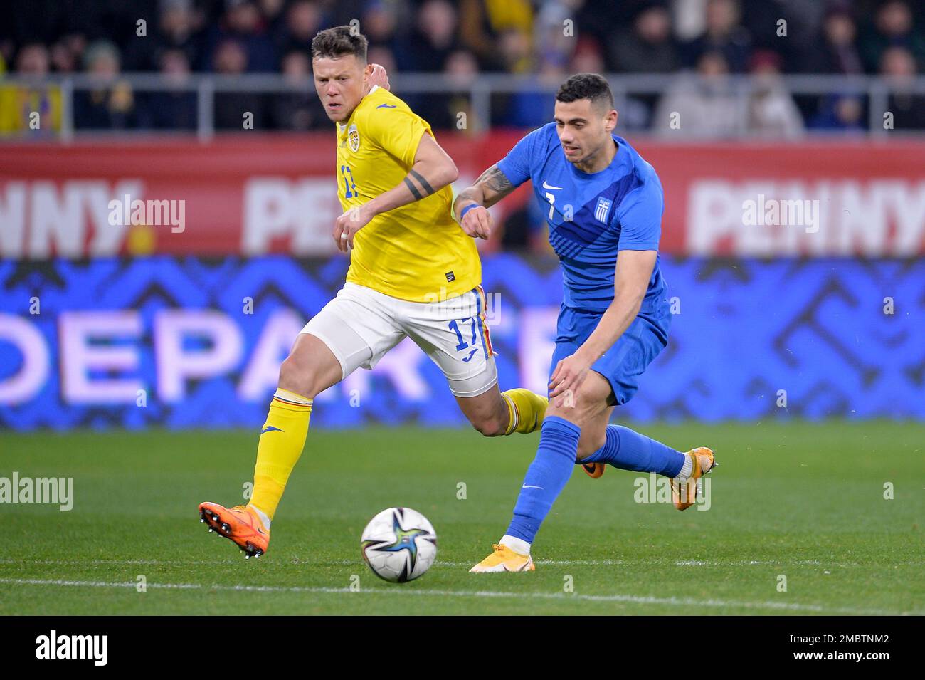 Romania's Adrian Rus, left, challenges for the ball with Greece's Giorgos Giakoumakis, right, during the international friendly soccer match between Romania and Greece at the Steaua Bucharest stadium in Bucharest, Romania, Friday, March 25, 2022. (AP Photo/Alexandru Dobre) Foto Stock
