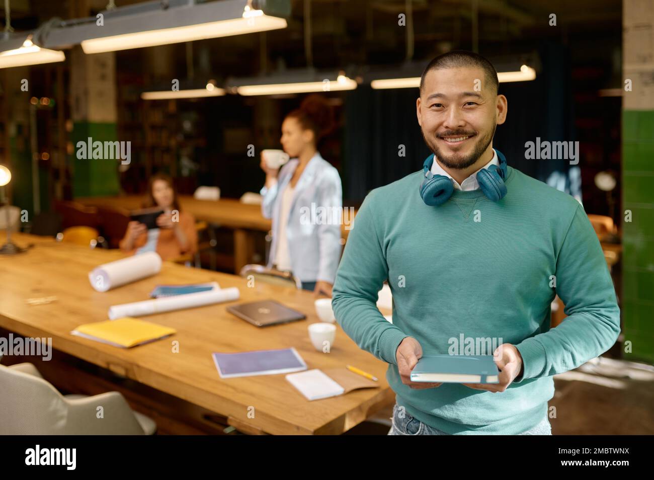 Ritratto di giovane felice freelance nello spazio di coworking Foto Stock