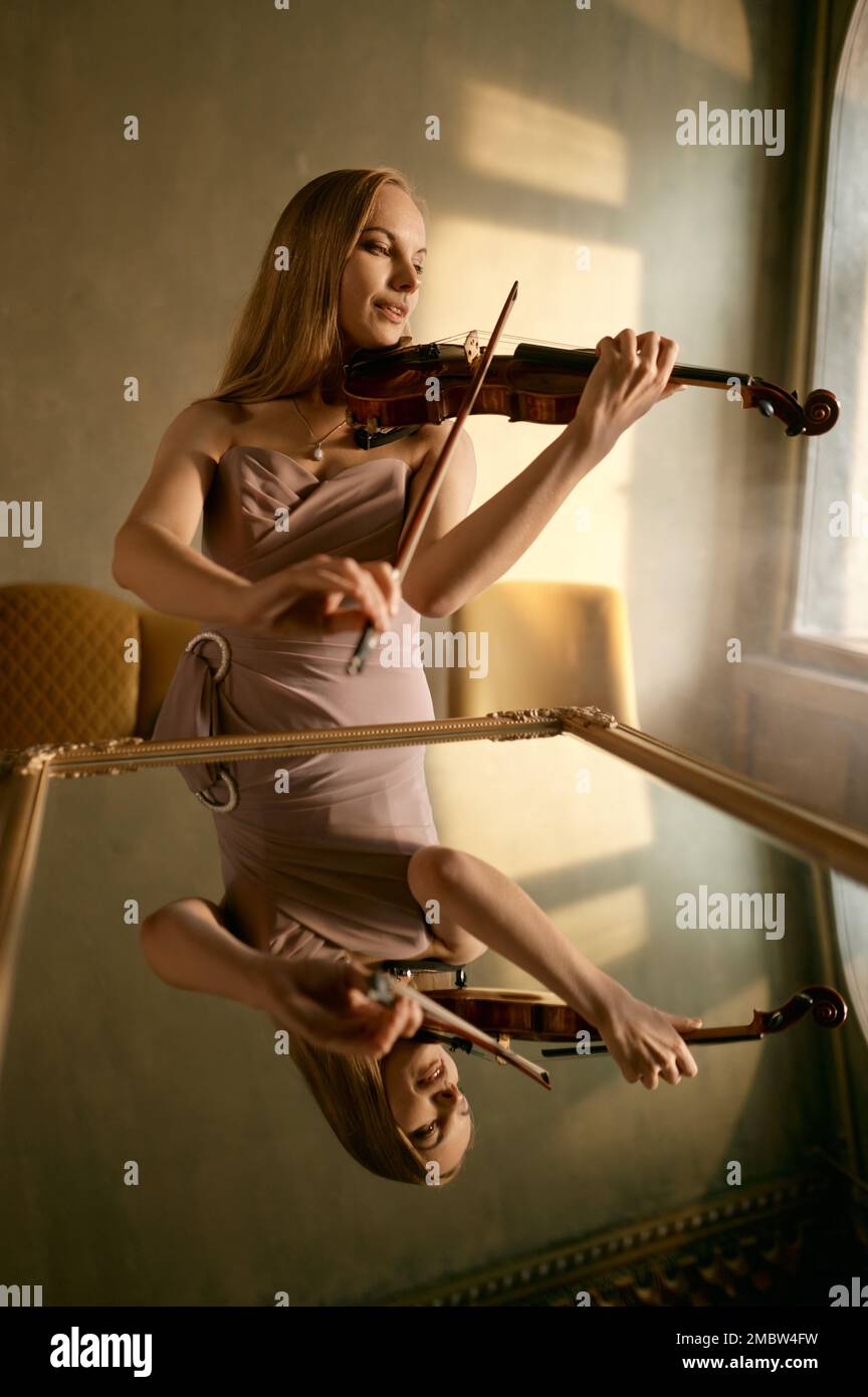 Giovane donna che suona il violino, ritratto con riflesso in specchio Foto Stock