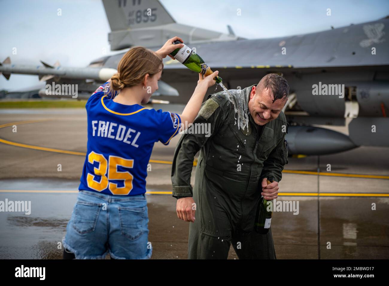 STATI UNITI Jesse J. Friedel, comandante di 35th Fighter Wing (FW), viene spruzzato con champagne da sua figlia dopo il suo volo fini alla base aerea di Misawa, Giappone, 22 giugno 2022. I membri della famiglia e dei servizi di tutto il 35th° FW e della Japan Air Self-Defense Force hanno partecipato al volo fini di Friedel per celebrare e mostrare il supporto prima della sua partenza da Misawa. Foto Stock