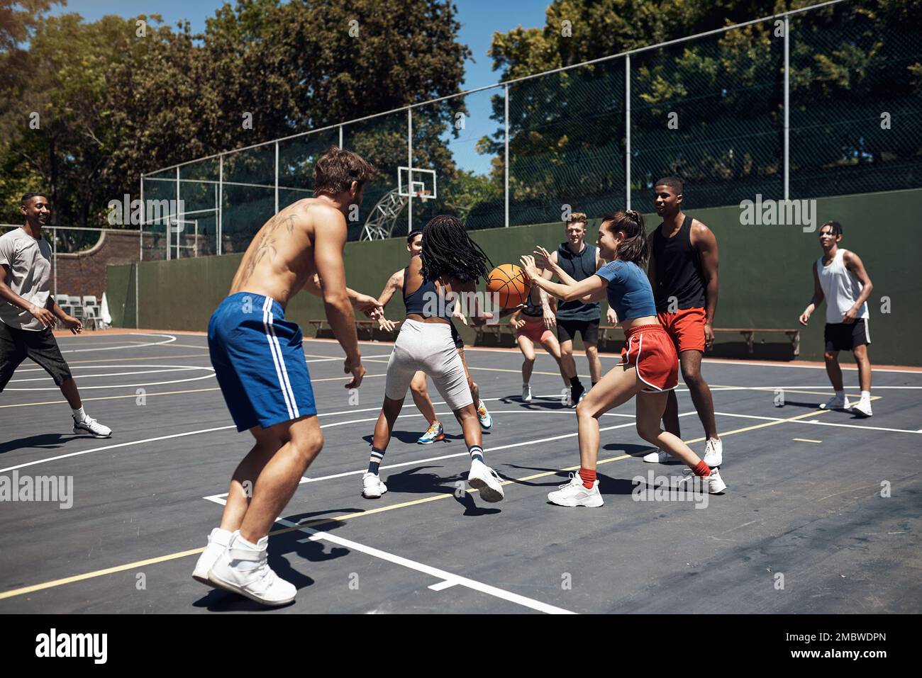 Theres niente di meglio che giocare con i vostri amici sul campo. un gruppo di giovani sportivi che giocano a basket su un campo sportivo. Foto Stock