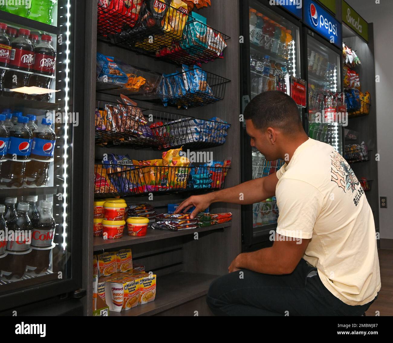 Un dormitorio Atlantis Airman guardare attraverso la selezione mini-mercato al dormitorio Atlantis su Whiteman Air Force base, Missouri, 22 giugno 2022. Il mini-mercato è destinato a portare la base shoppette a dormitorio Airmen che hanno turni di swing o sono solo bisogno di uno spuntino a tarda notte. Foto Stock