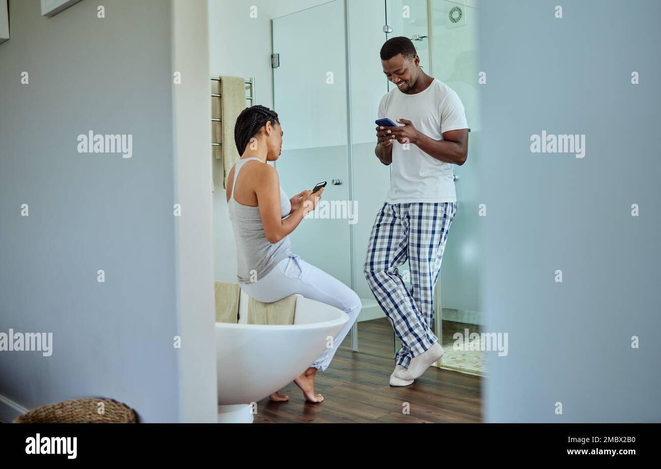 Social media, app e coppia nera al telefono in bagno per notizie, siti Web e chat. Comunicazione, felice e africano uomo e donna che legge divertente Foto Stock
