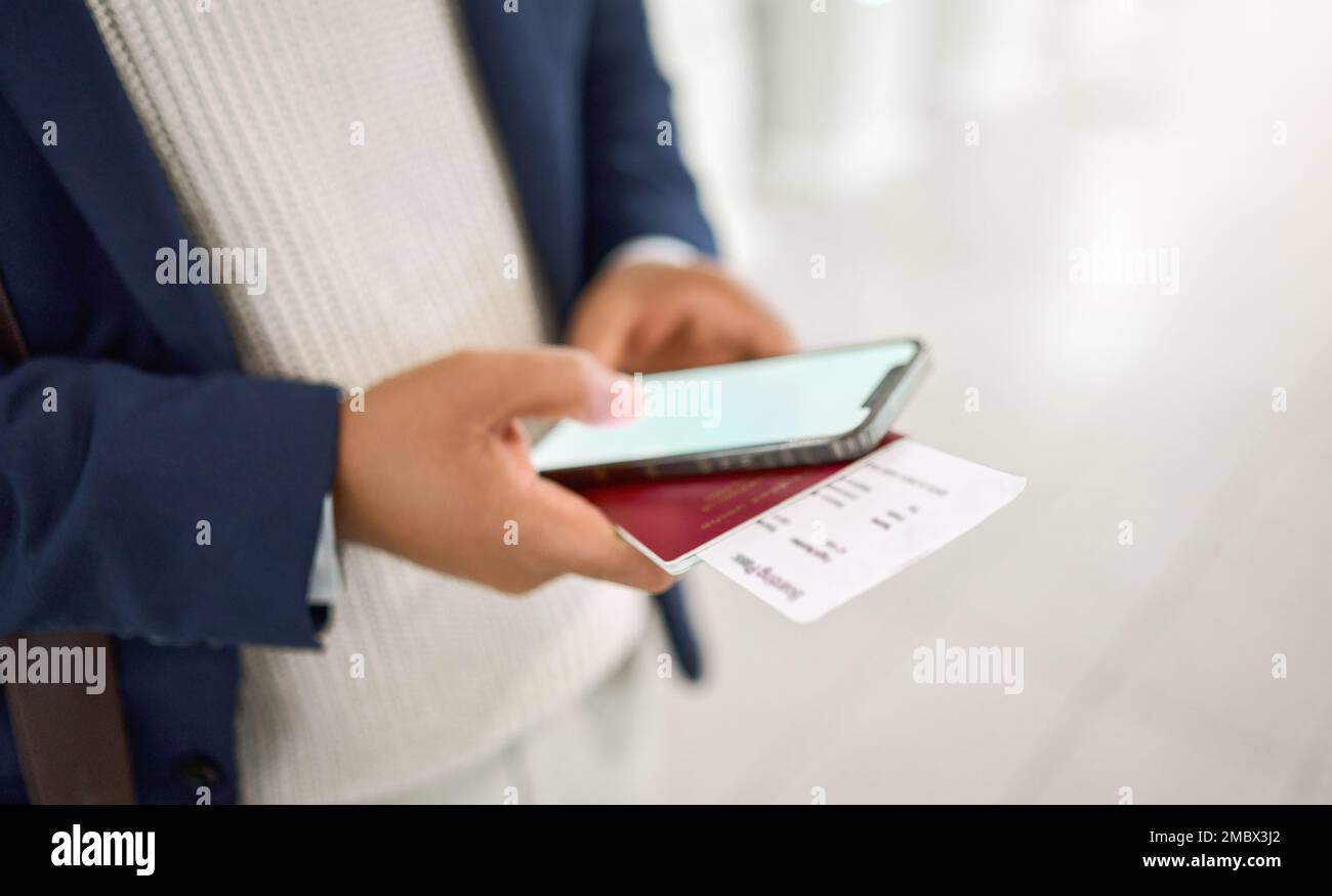 Chat a mani, telefoni e passaporti, digitazione o invio di SMS sull'app mobile o controllo degli orari dei voli in aeroporto. Mano di azienda dipendente holding Foto Stock