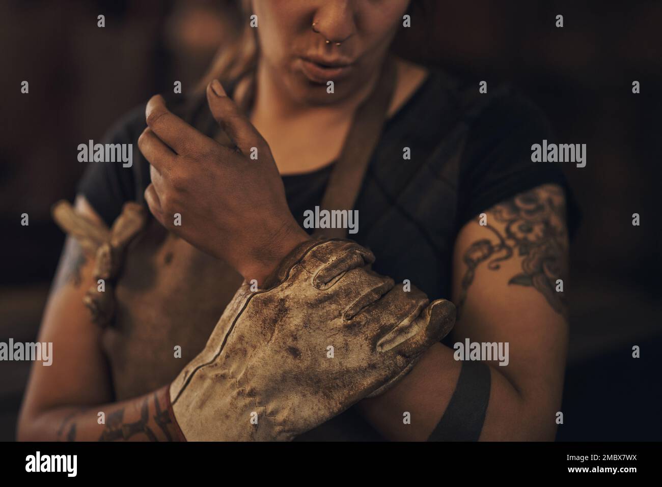 Può succedere lo slittamento, stare al sicuro. una donna che sperimenta dolore al polso mentre lavora in una fonderia. Foto Stock