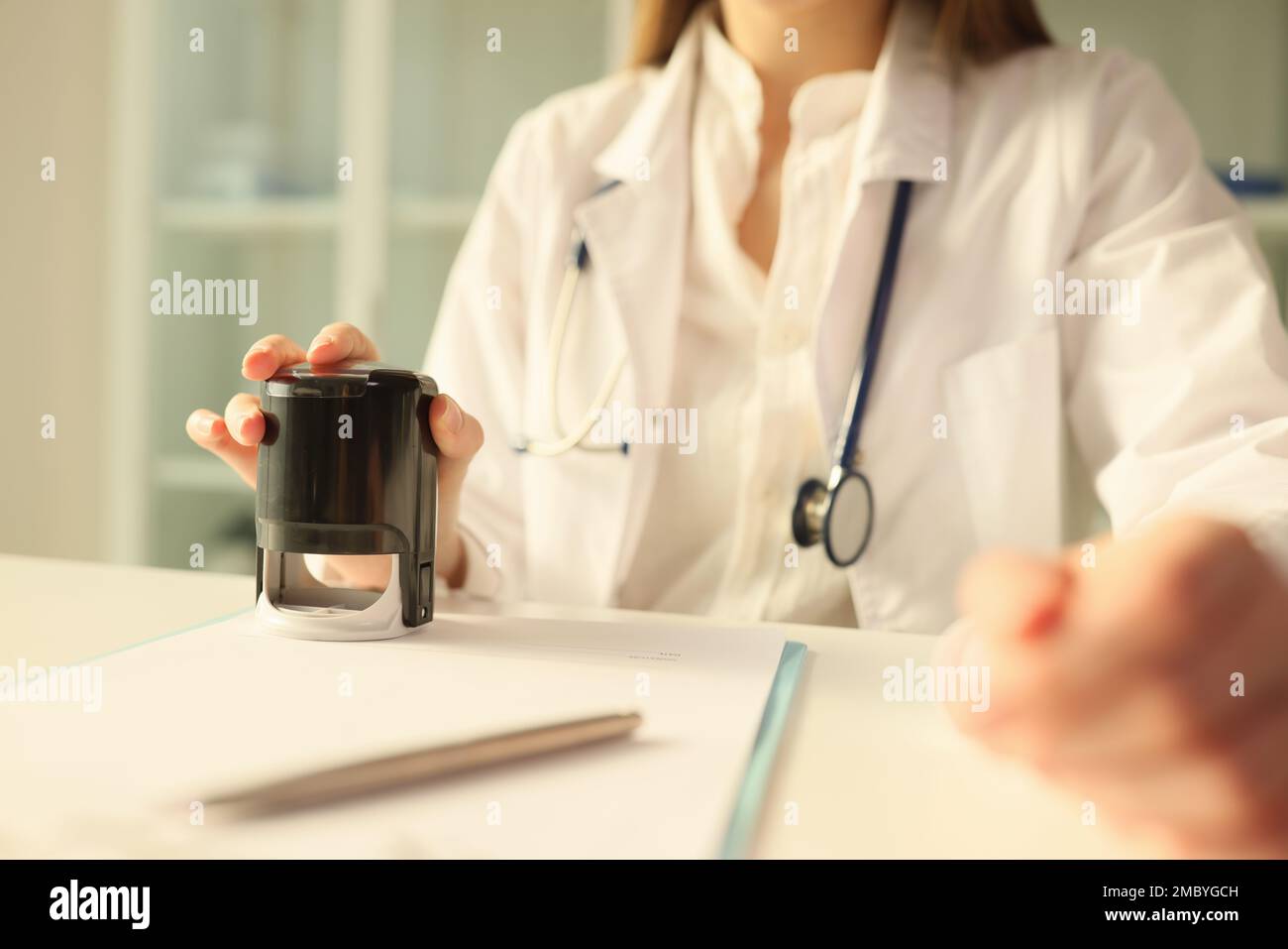Medico che mette il timbro su documenti medici importanti closeup Foto Stock