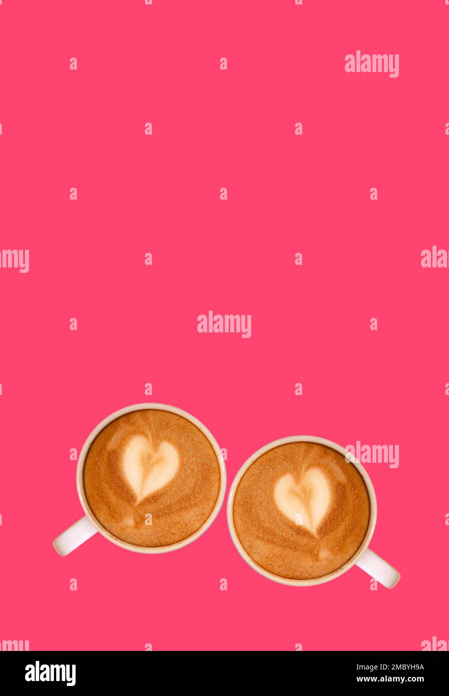 Due caffè Cappuccino con latte Art a forma di cuore su sfondo rosa caldo Foto Stock