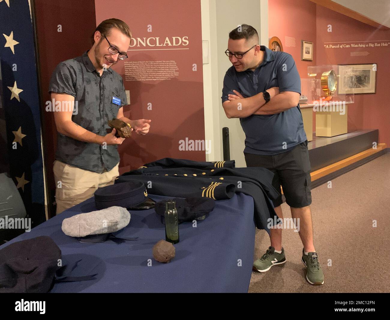 Ethan Dykes, un internista al museo navale di Hampton Roads, si impegna con i visitatori nella galleria della Guerra civile del museo su manufatti e oggetti associati alla USS Cumberland. Cumberland affondò durante un fidanzamento con il montone confederato, CSS Virginia il 8 marzo 1862. Il museo è il deposito ufficiale per i manufatti recuperati dal sito del relitto della USS Cumberland. Foto Stock