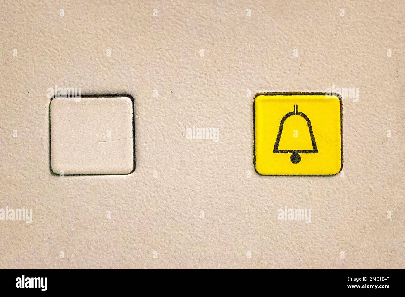 Pulsante giallo quadrato dell'ascensore per chiamare l'assistenza in caso di emergenza Foto Stock