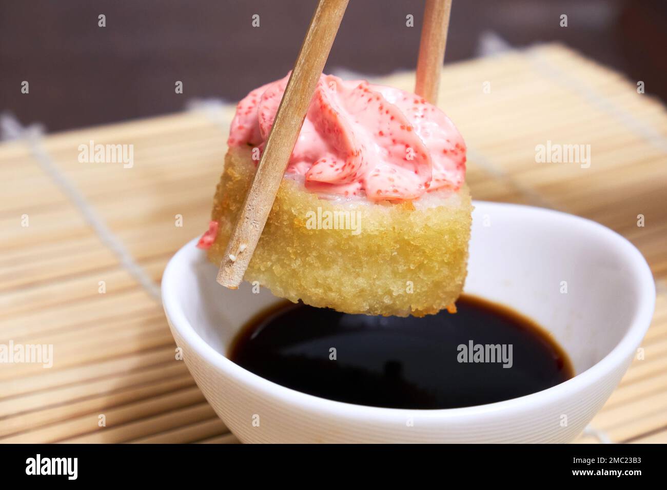 Chopsticks prendere sushi. Panini di sushi e salsa di soia Foto Stock