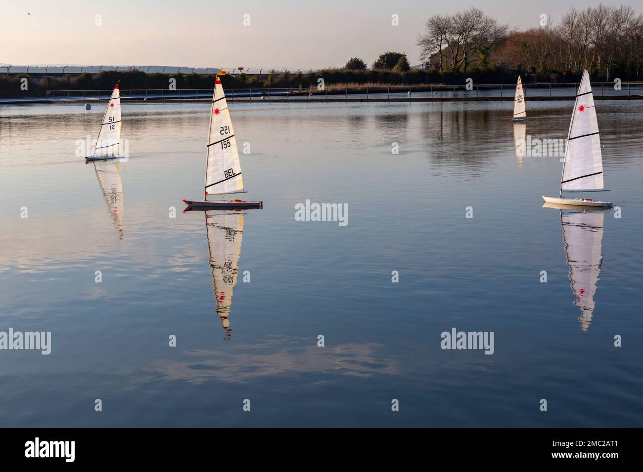 Poole, Dorset, Regno Unito. 21st gennaio 2023. Tempo nel Regno Unito: La mattina gelida e fredda a Poole non scoraggia gli appassionati di barche radiocomandate che corrono intorno al lago di Poole Park con le loro barche laser. Il vento piccolo e le zone congelate rendono difficile le corse, ma creano una scena serena e tranquilla con bei riflessi al sole. Credit: Carolyn Jenkins/Alamy Live News Foto Stock