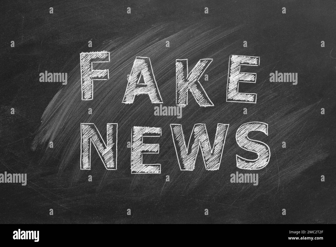 La parola FALSO NOTIZIE scritte in gesso su una lavagna. Concetto di informazione e disinformazione. Illustrazione disegnata a mano. Foto Stock