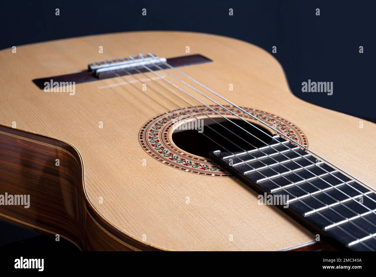 Chitarra classica isolata su sfondo nero con una bella rosetta a mosaico, vista dall'alto. Bel legno brasiliano - Pau ferro Foto Stock