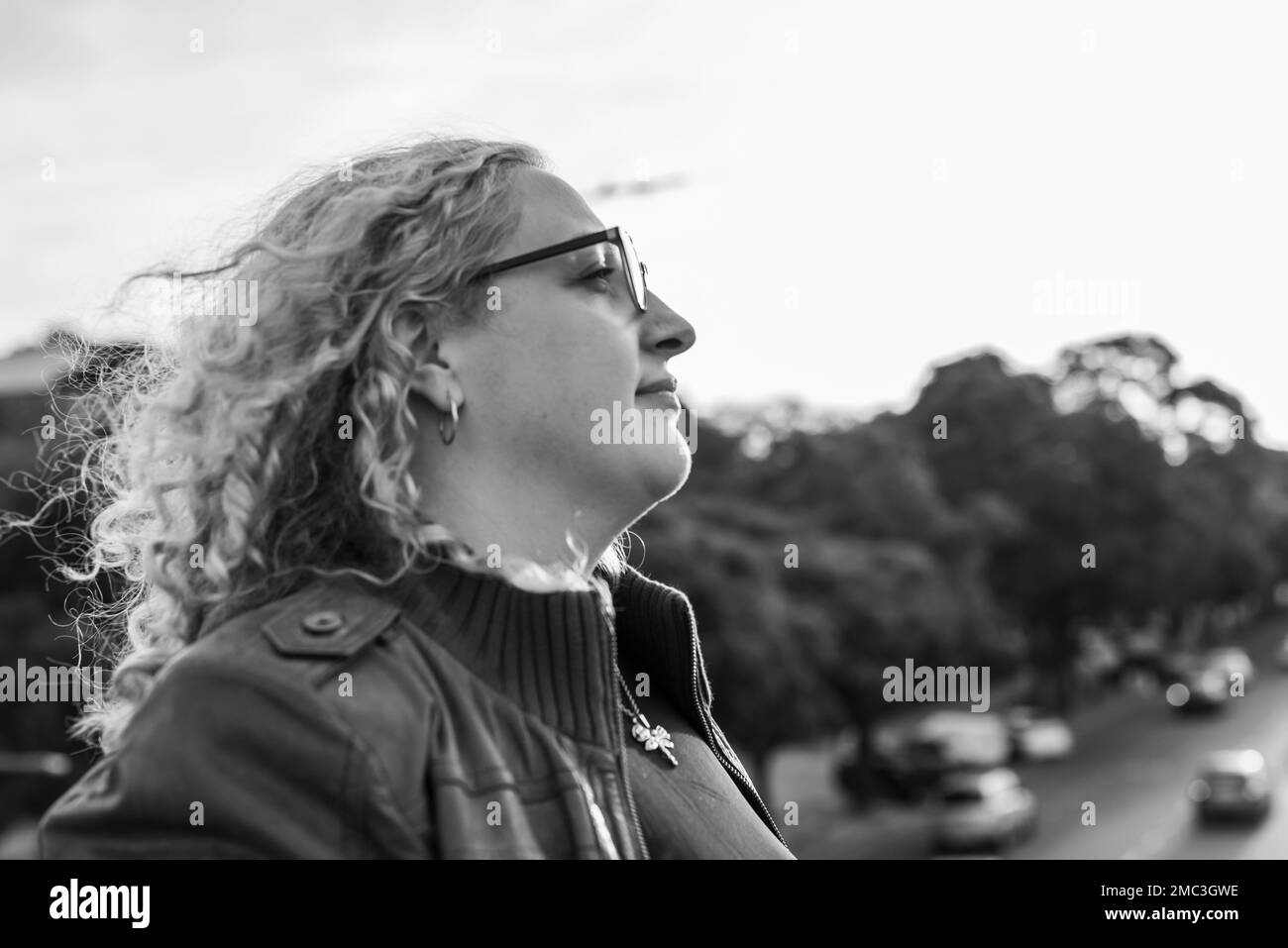 Vista laterale di una donna bionda e ricciola più-misura Foto Stock