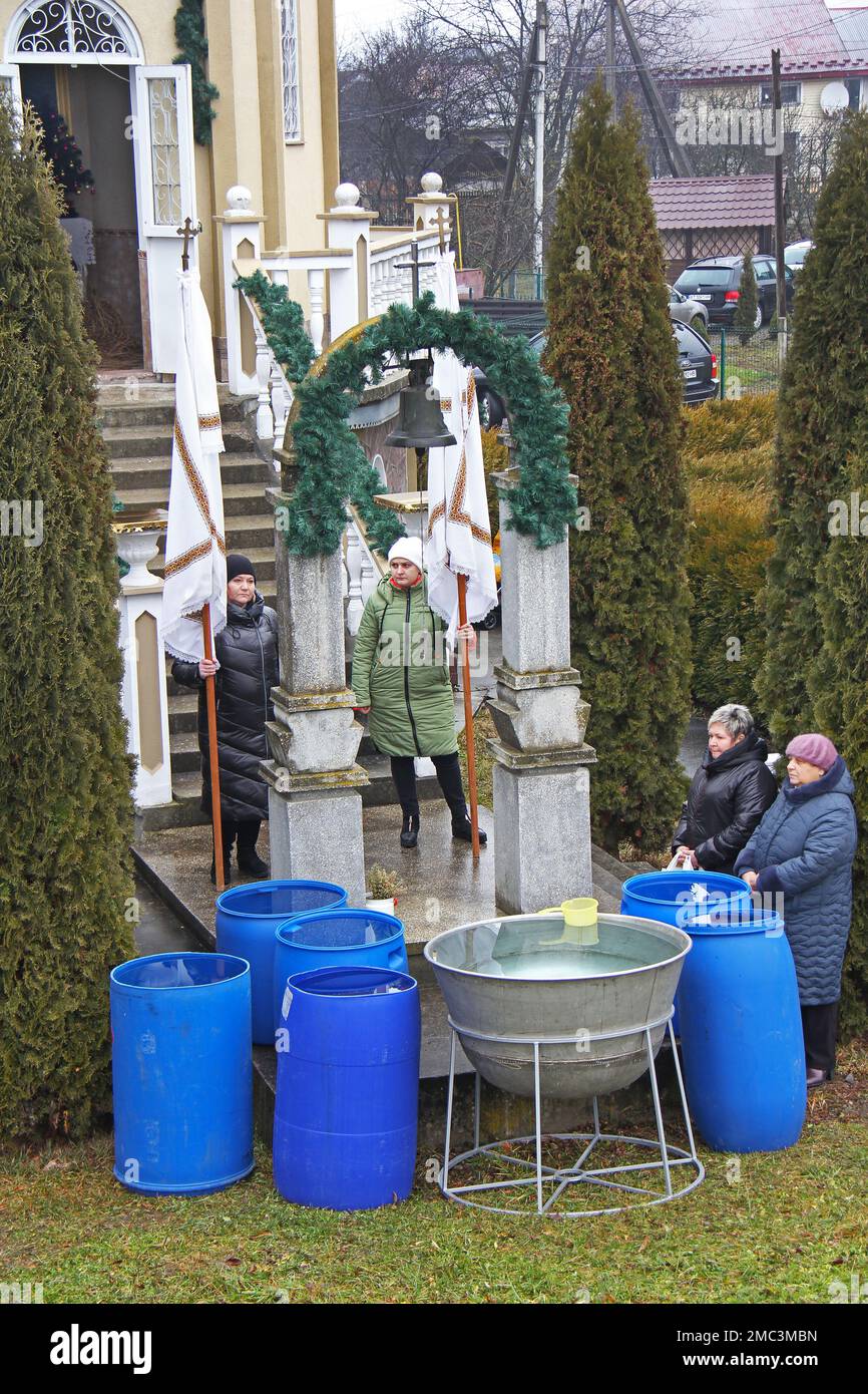 Quattro donne credenti stanno accanto alla cappella, in attesa del rito di Epifania. Fiume Voron in Tysmenytsia, regione di Ivano-Frankivsk, Ucraina. Gennaio 19, Foto Stock