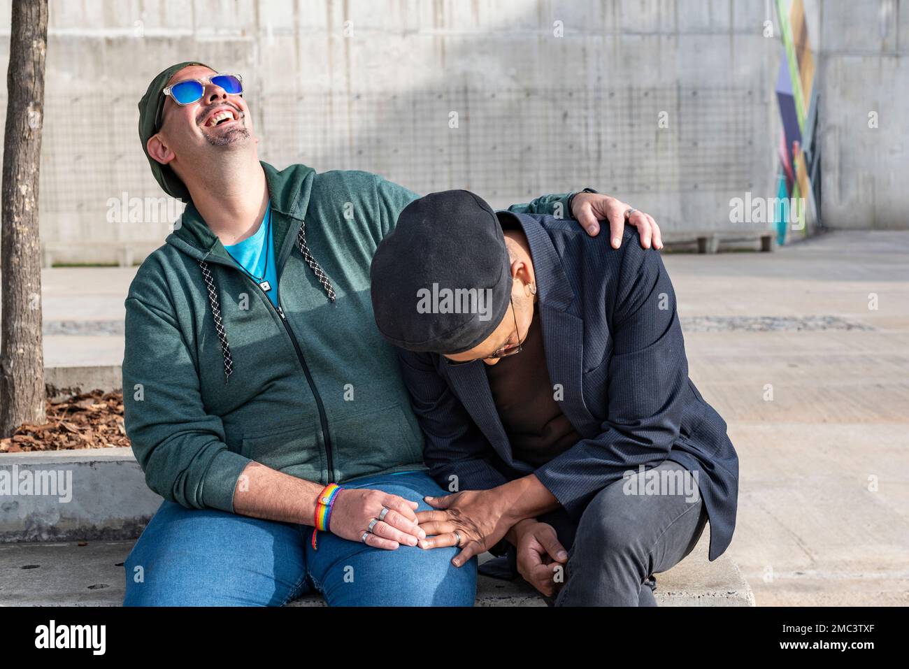 Coppia gay maschio tenendo le mani e ridendo forte Foto Stock