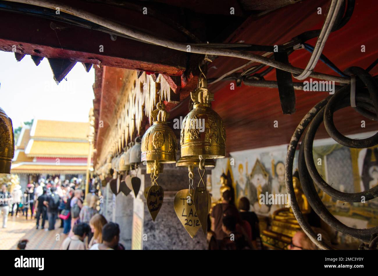 Una fila di campane dorate appese ad un tempio buddista Foto Stock