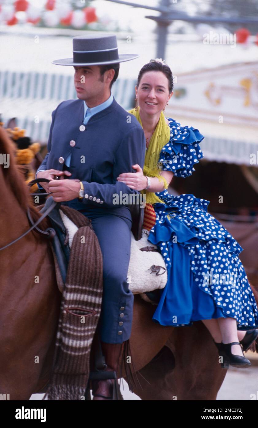 Coppia a cavallo alla Fiera di Siviglia, Andalusia, Spagna Foto Stock