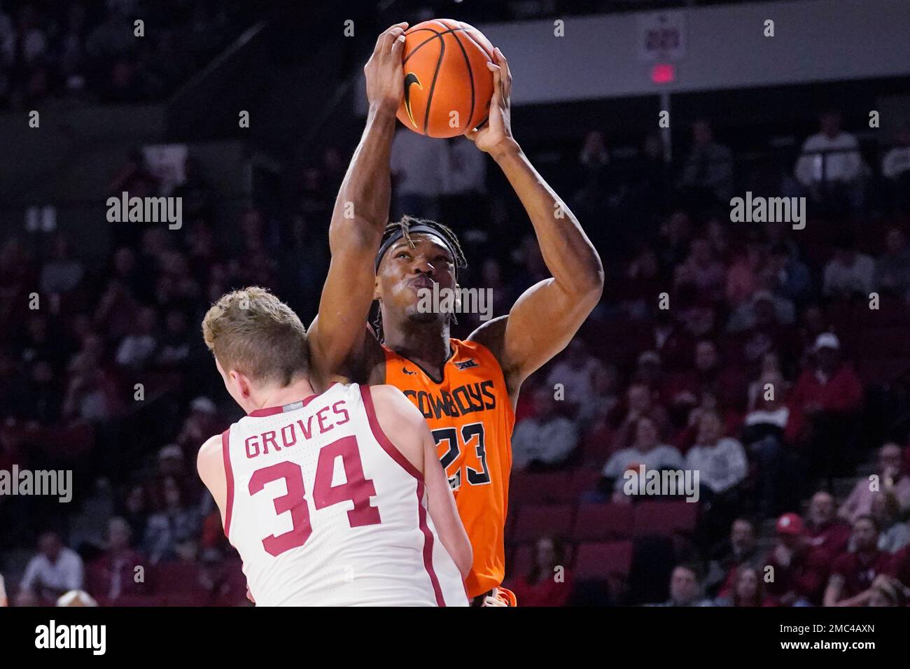 Oklahoma State forward Tyreek Smith (23) is fouled by Oklahoma forward Jacob Groves (34) in the first half of an NCAA college basketball game Saturday, Feb. 26, 2022, in Norman, Okla. (AP Photo/Sue Ogrocki) Foto Stock
