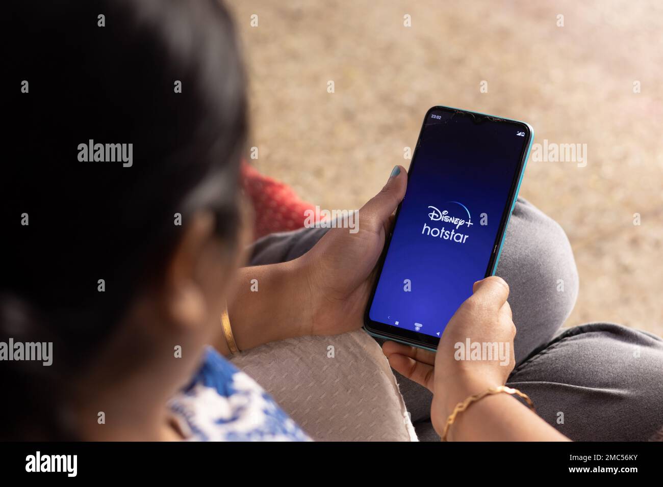 Birbhum, Bengala Occidentale, India - Dicembre 27th 2022: Una donna indiana con smartphone che guarda l'app disney Plus hotstar a casa Foto Stock
