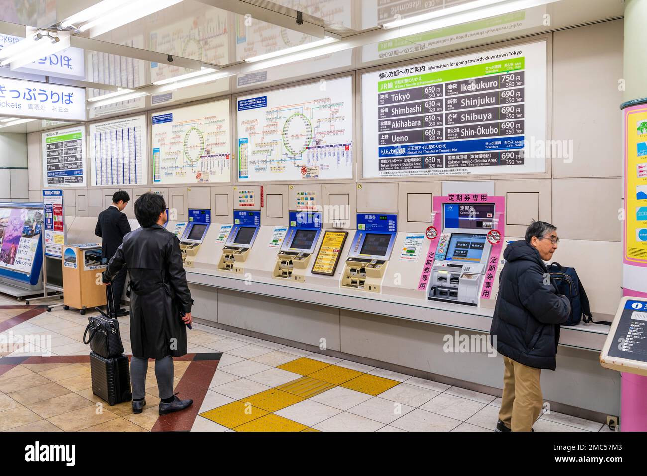 Tokyo Haneda. Interno di un terminale. Fila di Tokyo Monorail distributori automatici di biglietti e due persone che li utilizzano. Le macchine di cui sopra, le mappe e i prezzi. Foto Stock