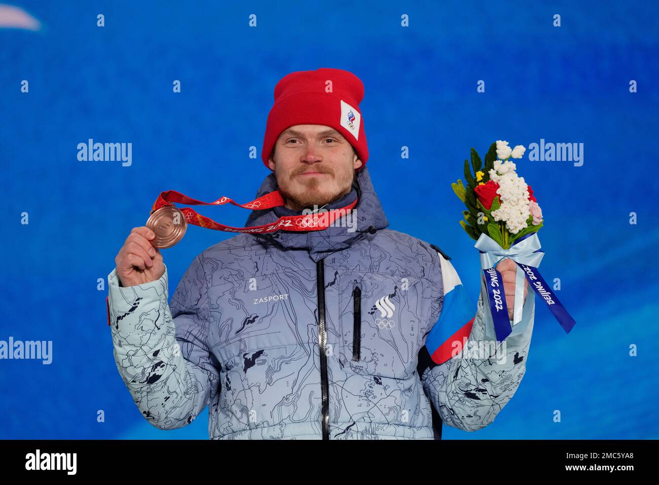 Bronze medalist Sergey Ridzik, of the Russian Olympic Committee, poses during a medal ceremony for the freestyle skiing men's cross competition at the 2022 Winter Olympics, Friday, Feb. 18, 2022, in Zhangjiakou, China. (AP Photo/Alessandra Tarantino) Foto Stock