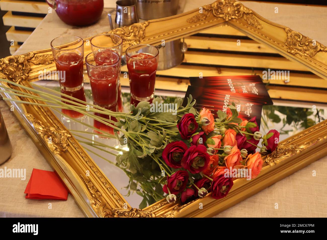 Uno splendido specchio d'oro con un bouquet di rose ben allestito Foto Stock