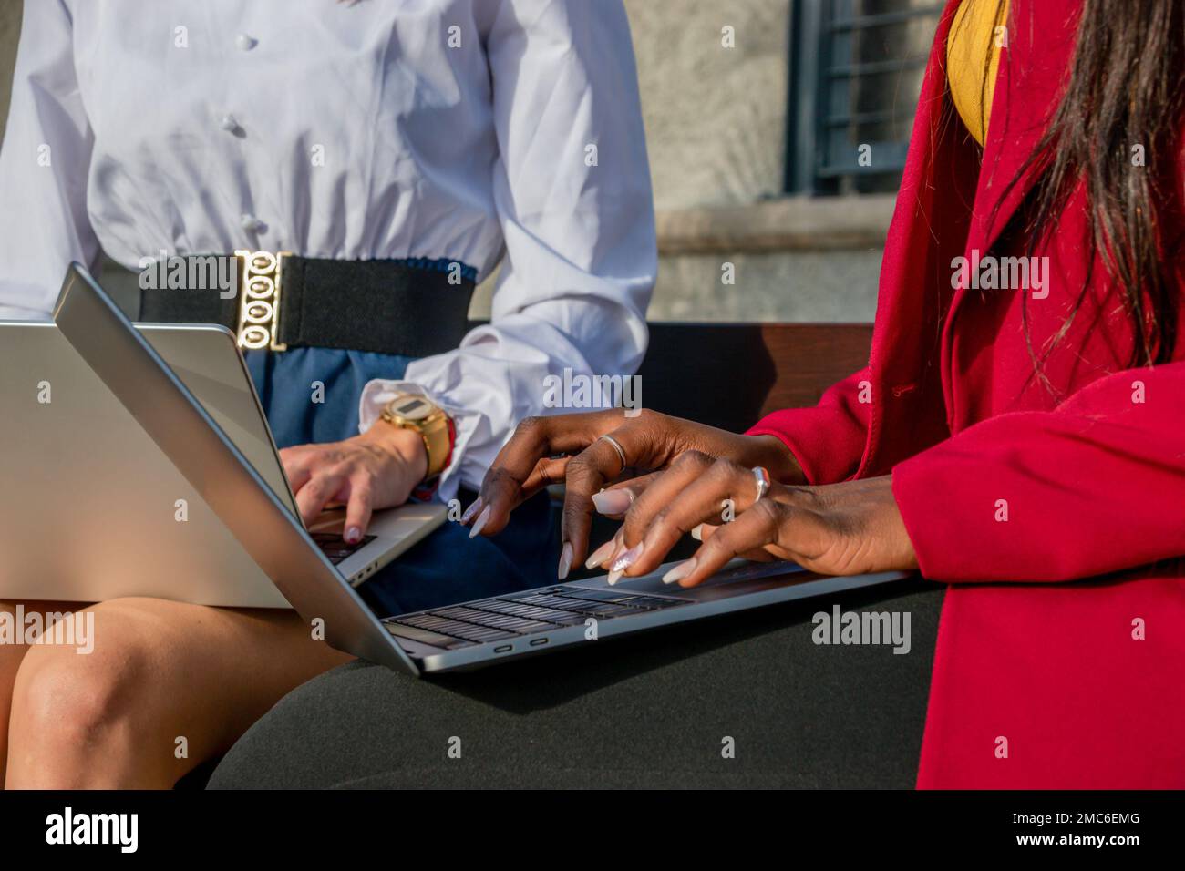 Primo piano delle mani di due uomini d'affari che scrivono con i loro computer portatili all'aperto. Concetto di nomade digitale Foto Stock