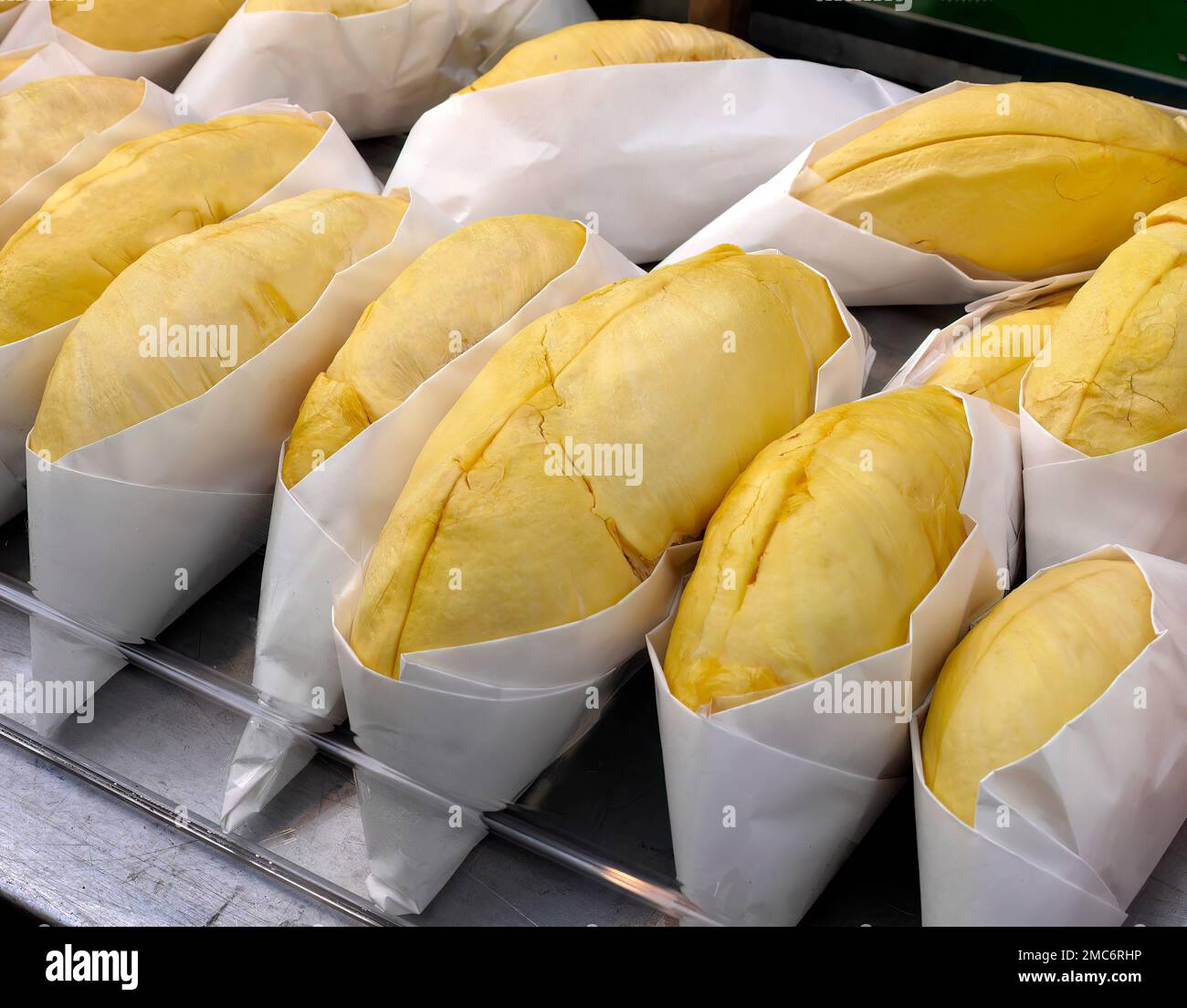 Primo piano rotolo di carne Durian di colore giallo dorato avvolto in carta bianca, pronta per mangiare, in vendita, sapore dolce, forma e forma naturale, Mar tropicale Foto Stock Primo piano rotolo di carne Durian di colore giallo dorato avvolto in carta bianca, pronta per mangiare, in vendita, sapore dolce, forma e forma naturale, Mar tropicale Foto Stock