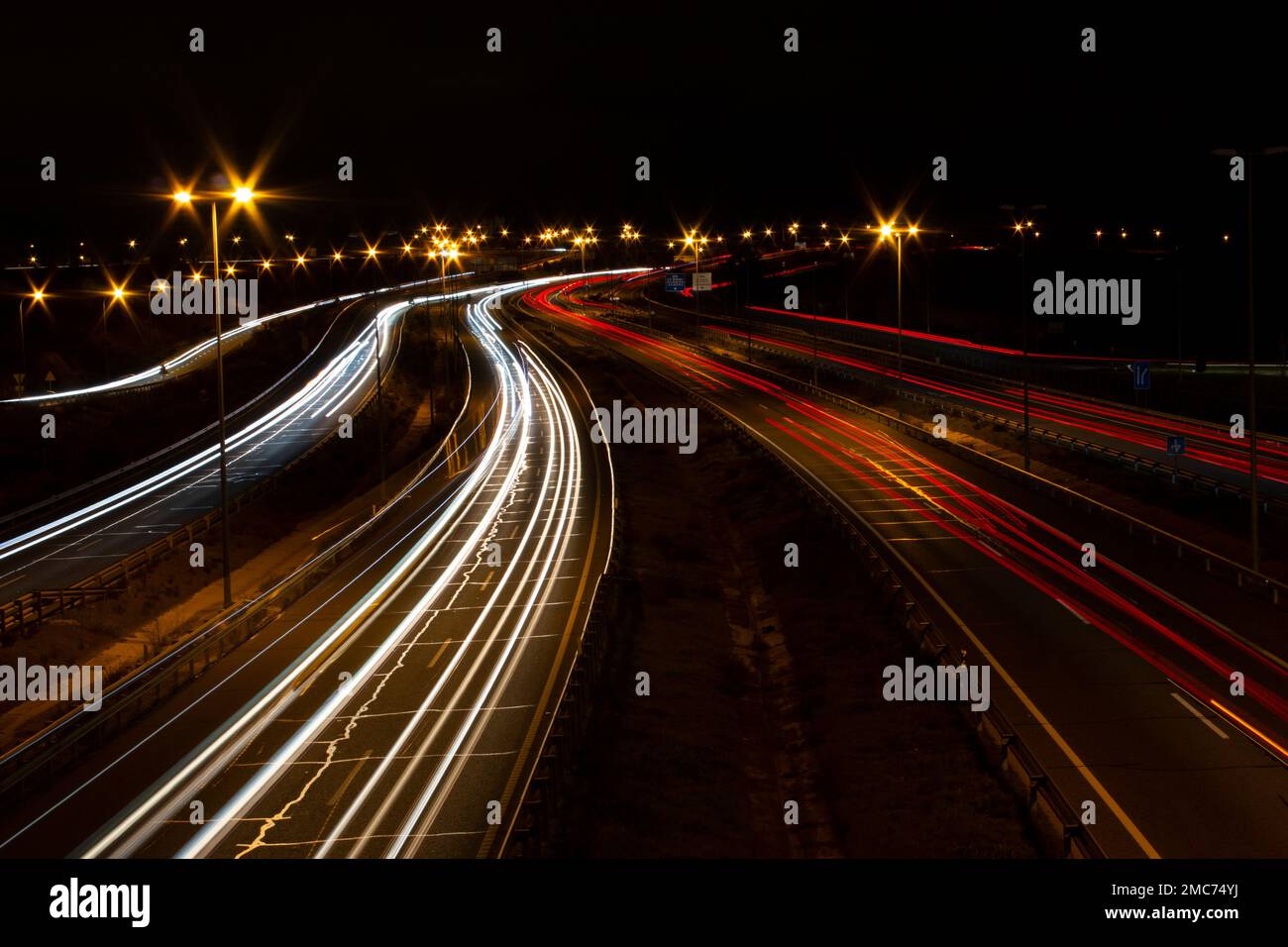 Sentieri leggeri da auto di notte su un'autostrada a più corsie a madrid Foto Stock