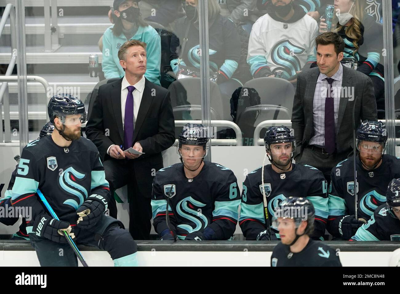 Seattle Kraken coach Dave Hakstol, left, and assistant coach Jay Leach stand behind the bench during the second period of the team's NHL hockey game against the Arizona Coyotes, Wednesday, Feb. 9, 2022, in Seattle. (AP Photo/Ted S. Warren) Foto Stock