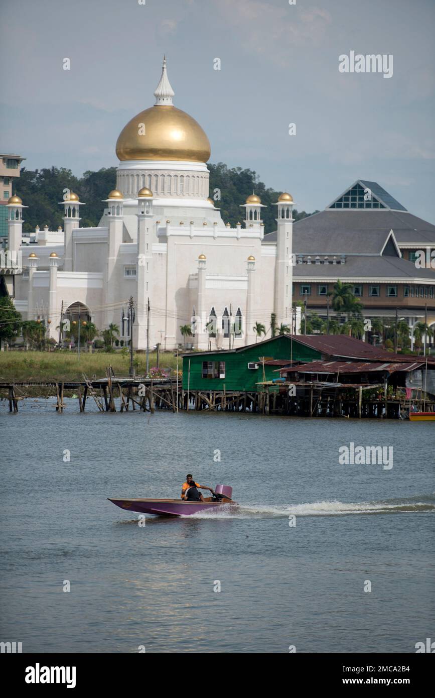 Motoscafo sul fiume con l'opulenta Moschea del Sultano Omar Ali Saifuddien accanto alle capanne sullo sfondo dal Ponte di Edimburgo, dal Fiume Kedayan e dal Bandar seri Begaw Foto Stock