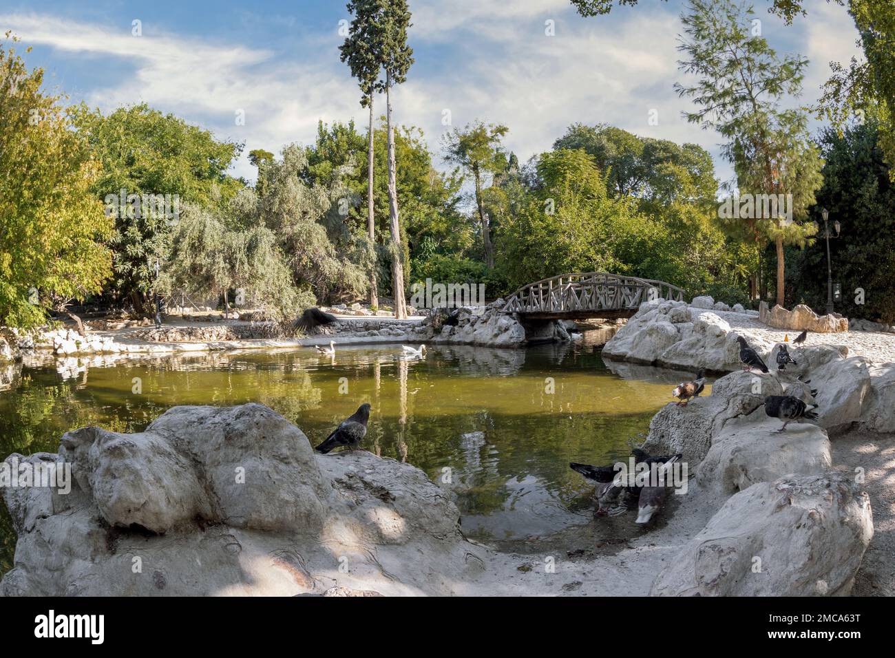 Vista panoramica sul lago artificiale con il ponte in legno presso il Giardino Nazionale di Atene - Grecia Foto Stock