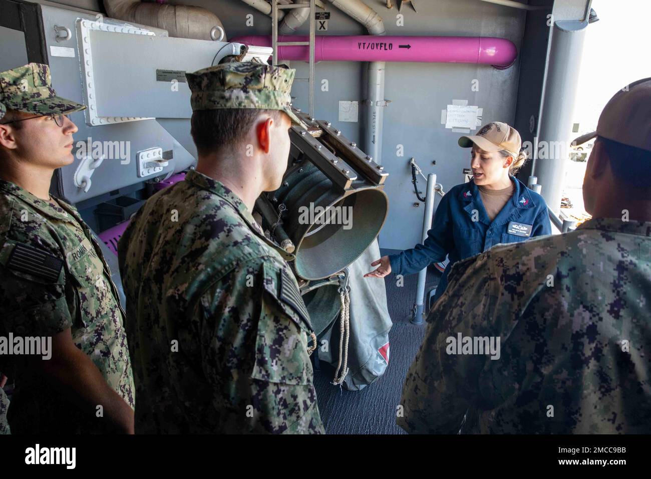 220629-N-NY430-1088 SAN DIEGO (29 giugno 2022) – il compagno di Boatswain 2nd Classe Hollie Williams parla ai giovani ufficiali di guerra di superficie che partecipano al Basic Division Officer Course (BDOC) durante un tour a bordo di una nave d'assalto anfibia USS Makin Island (LHD 8). Il BDOC è un programma formativo di nove settimane che copre le basi dell'ingegneria, i fondamenti degli ufficiali di divisione, il controllo dei danni e la navigazione per gli ufficiali di guerra di superficie (SWO). Makin Island è una nave d'assalto anfibio di classe Wasp ospita a San Diego. Foto Stock