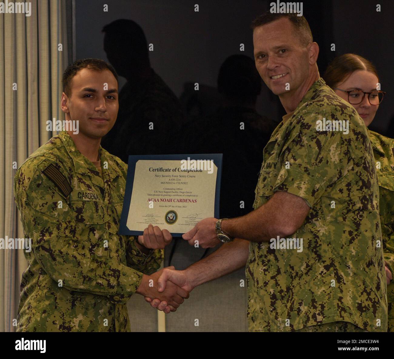 220629-N-EJ241-1004 DIEGO GARCIA, British Indian Ocean Territory (29 giugno 2022) – Air Traffic Controller Airman Apprentice Noah Cardenas, assegnato agli Stati Uniti Navy Support Facility (NSF) Diego Garcia, riceve il suo certificato di completamento dal Capt. Richard D. Payne, comandante della NSF Diego Garcia, dopo essersi laureato alla Auxiliary Security Forces (ASF) Academy. Il personale della ASF è un membro del servizio attivo che aumenta il personale di sicurezza di base durante situazioni di emergenza, attacchi terroristici, disastri naturali, disordini civili, esercitazioni ed eventi speciali che richiedono livelli elevati di Foto Stock