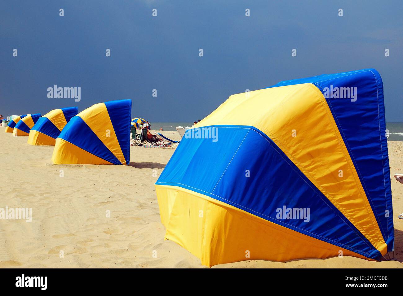 Capanne sulla spiaggia pronti a custodire i raggi ultravioletti del sole e una tempesta imminente a Virginia Beach in una giornata di vacanze estive Foto Stock