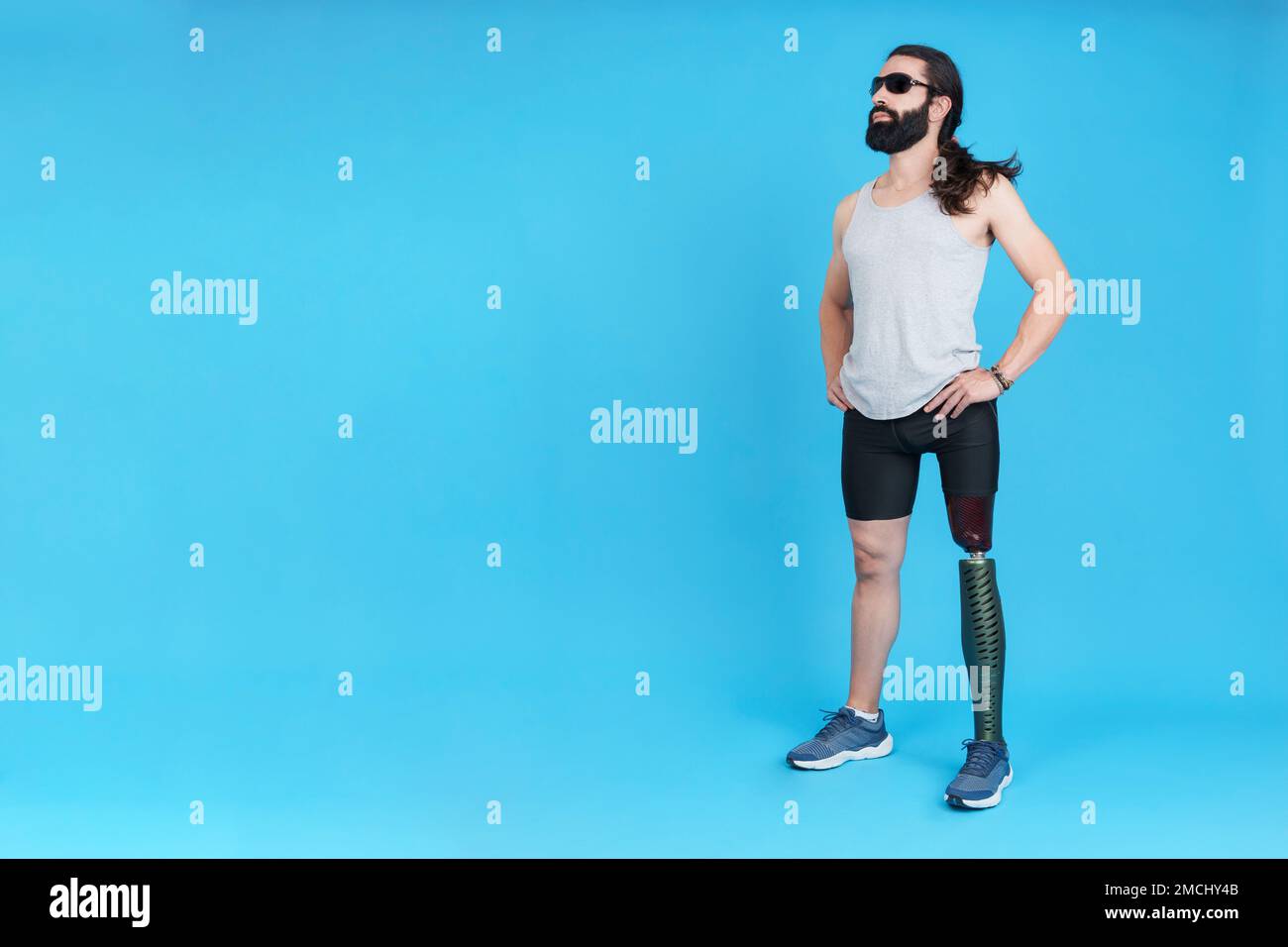 Uomo sportivo con occhiali da sole in piedi con una gamba protesica Foto Stock