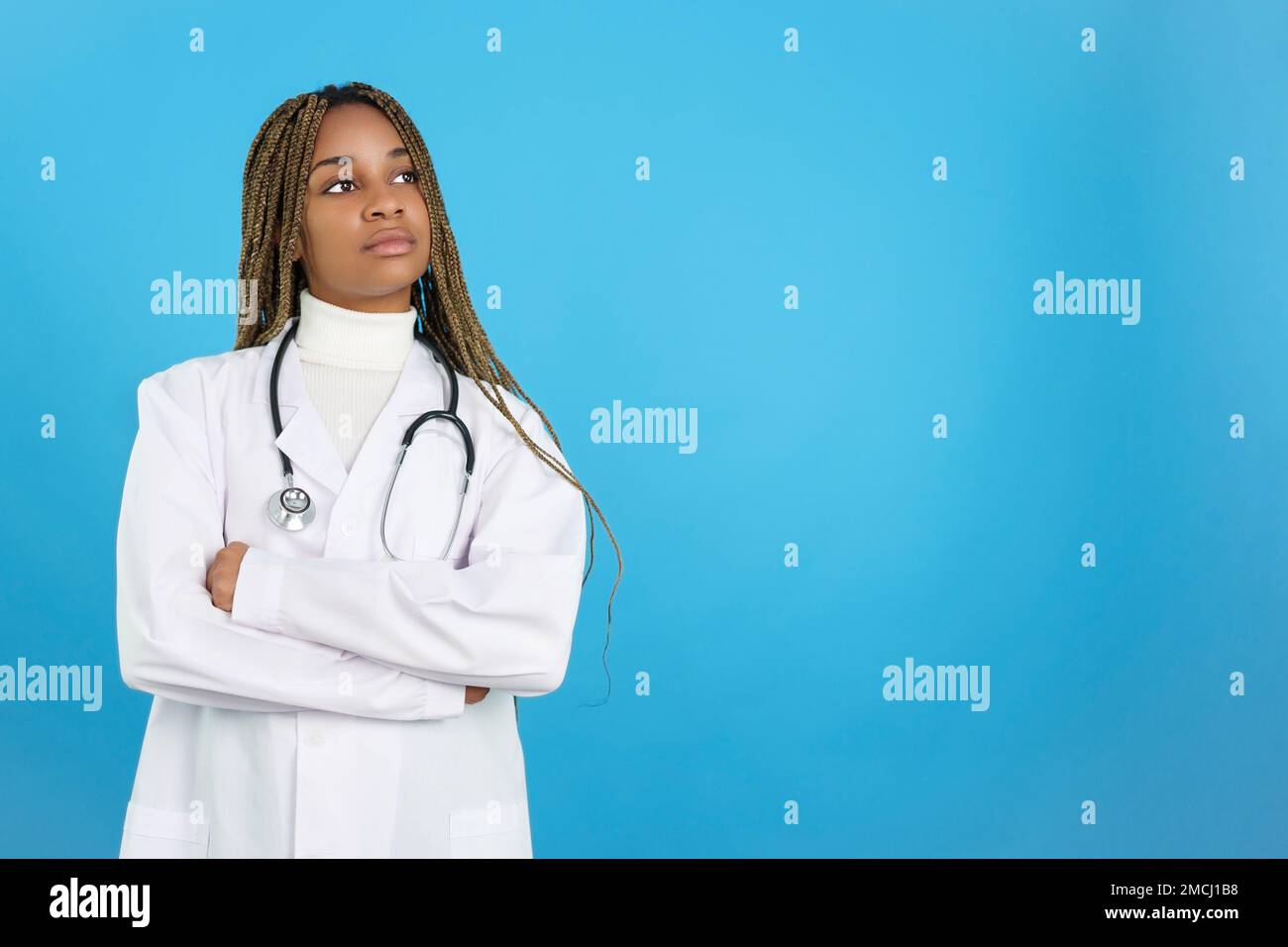 Seria dottoressa africana in uniforme con le braccia piegate Foto Stock
