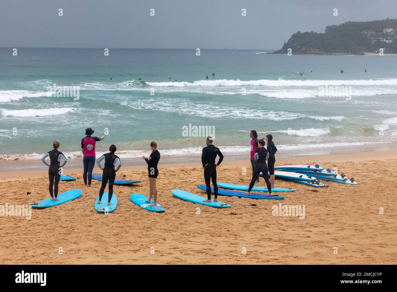 Lezioni di surf Impara a fare surf a Manly Beach Sydney, istruttore di surf insegna a un gruppo di principianti come fare surf, Sydney, NSW, Australia Foto Stock