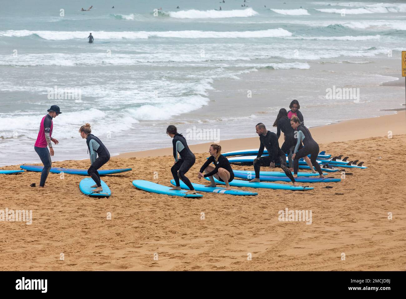 Lezioni di surf Impara a fare surf a Manly Beach Sydney, istruttore di surf insegna a un gruppo di principianti come fare surf, Sydney, NSW, Australia Foto Stock