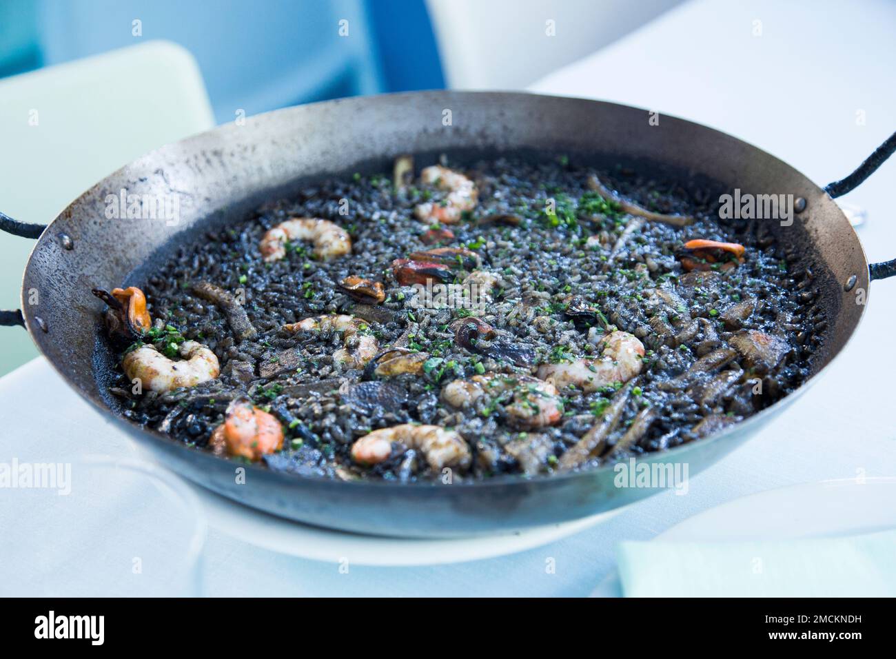 Ricetta originale spagnola per la paella nera con pesce Foto Stock