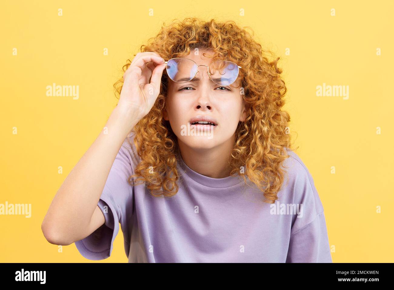 Giovane donna che toglie i suoi occhiali per vedere lontano Foto Stock