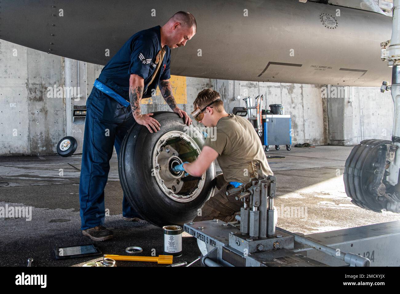 Senior Airman Owen Schott, a sinistra, e Airman 1st Class Trevor Finley, a destra, 44th manutenzione unità aeromobili, applicare il lubrificante a una ruota di atterraggio principale su Kadena Air base, Giappone, 6 luglio 2022. La lubrificazione della ruota evita la corrosione, garantendo la capacità di Kadena di mantenere un Indo-Pacific libero e aperto. Foto Stock