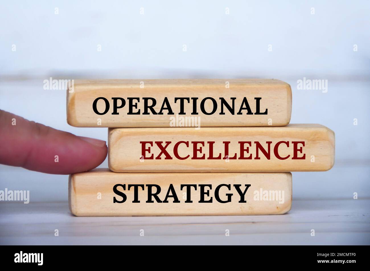 Puntare a mano il testo della strategia di eccellenza operativa su blocchi di legno. Eccellenza operativa e concetto di strategia aziendale. Foto Stock