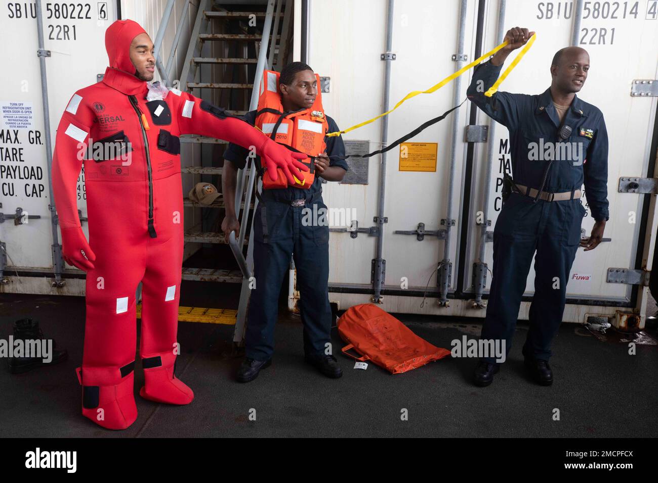 220708-N-TI693-1058 OCEANO INDIANO (8 luglio 2022) il compagno di Boatswain Seaman Tyshawn Hickson, a sinistra, da Mullins, South Carolina, indossa un abito da immersione, e Seaman Anthony Bridges, al centro, da Fort Washington, Maryland, indossa una giacca di salvataggio, mentre il capo Boatswain's Mate Derval Davis, da St Johns, Florida, fornisce l'addestramento di nave di abbandono a bordo della base marittima di spedizione della classe Lewis B. Puller USS Hershel 'Woody' Williams (ESB 4), 8 luglio 2022. Hershel "Woody" Williams è schierata a rotazione negli Stati Uniti Naval Forces Africa area of Operations, impiegato dagli Stati Uniti Sesta flotta, per difendere gli Stati Uniti, un Foto Stock