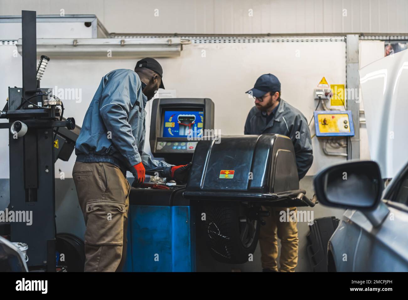Ingegneri che lavorano in un moderno negozio di riparazione auto utilizzando attrezzature all'avanguardia. Foto di alta qualità Foto Stock