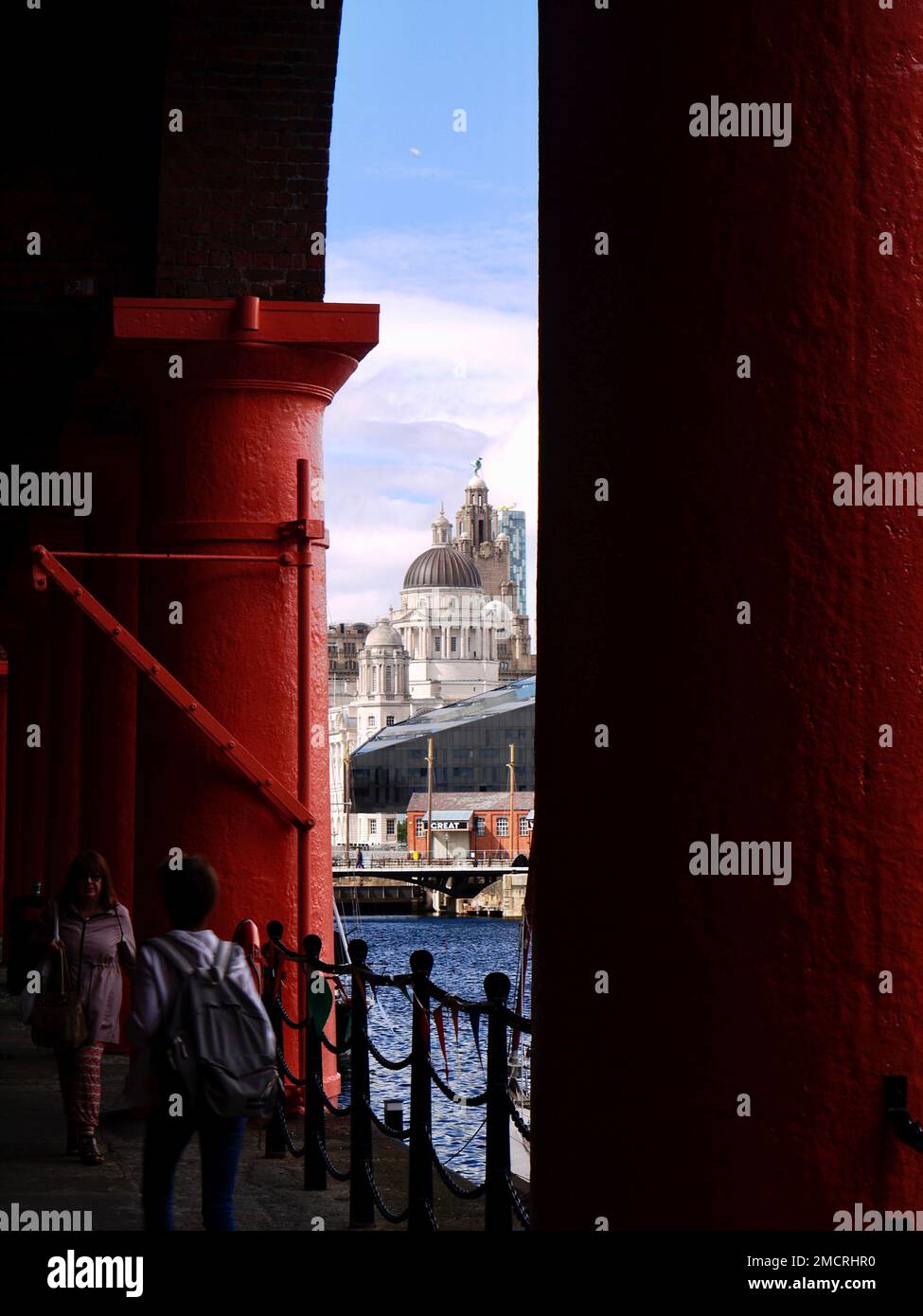 Il Liver Building, visto attraverso le imponenti colonne dipinte di rosso del rinnovato Royal Albert Dock, Liverpool Foto Stock