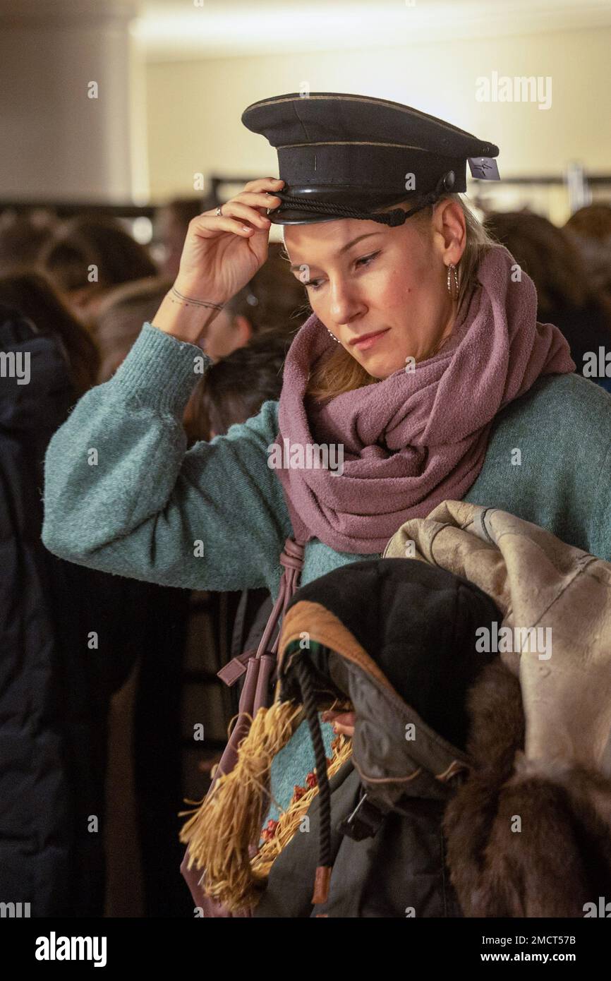 22 gennaio 2023, Sassonia, Dresda: Una donna mette un cappello sulla sua testa che ha trovato alla vendita del costume del Teatro di Stato Sassone nel Teatro dell'Opera Semper, mentre l'altro braccio è già pieno di pezzi in costume. In offerta sono pezzi unici realizzati a mano dalle produzioni di 'Nabucco', 'le nozze di Figaro', 'Carmen', 'la Cenerentola', 'Dr. Faust' e 'Mathis der Maler', tra gli altri. Foto: Daniel Schäfer/dpa - ATTENZIONE: Solo per uso editoriale in relazione al reporting corrente e solo con menzione completa del credito di cui sopra Foto Stock